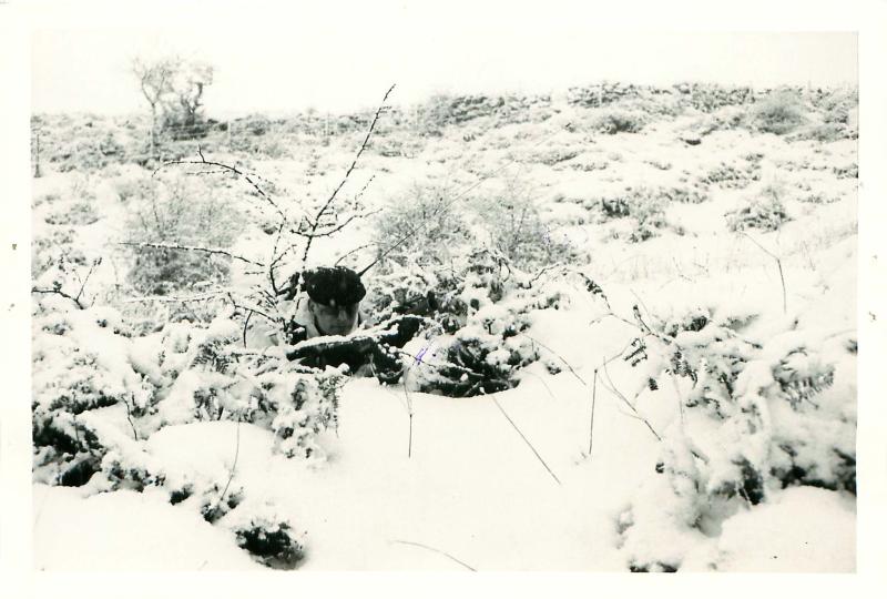 Private Lowton in covert observation position on snowy ground.
