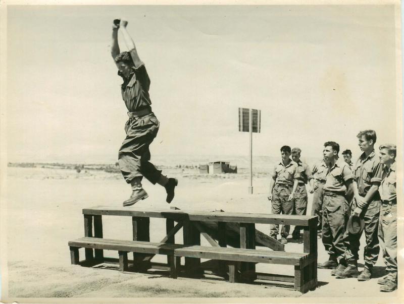 Troops practise parachute landing drills.
