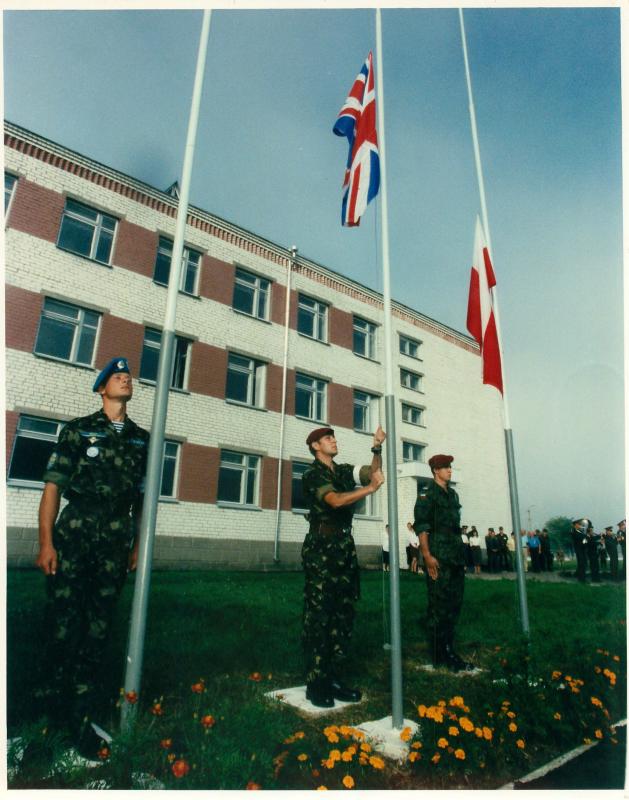 Three members of Russian Airborne Forces raise flags including the Union Flag.
