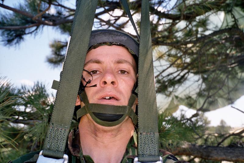Jason Connolly hanging around after landing in a tree on exercise, Wyoming, USA