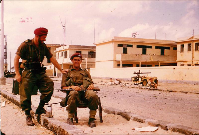 A French Liaison Officer stands with a seated British paratrooper, Suez, November 1956