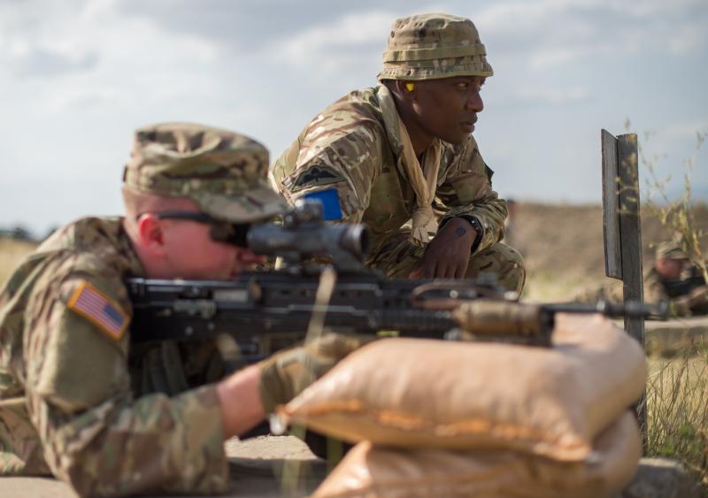 A soldier from the US 173rd Airborne Brigade fires the British Army’s SA80 A2 assault rifle, under the watchful eye of a 2 PARA soldier
