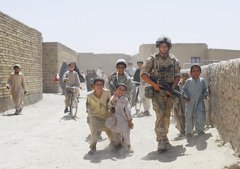 Soldier from 3 PARA on patrol alongside young Afghan locals, Kandahar, Aghanistan, 2008