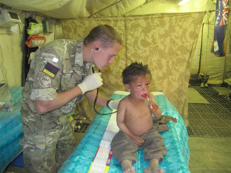A Doctor from 16 Medical Regiment, RAMC, treats a local boy, Afghanistan, 2011
