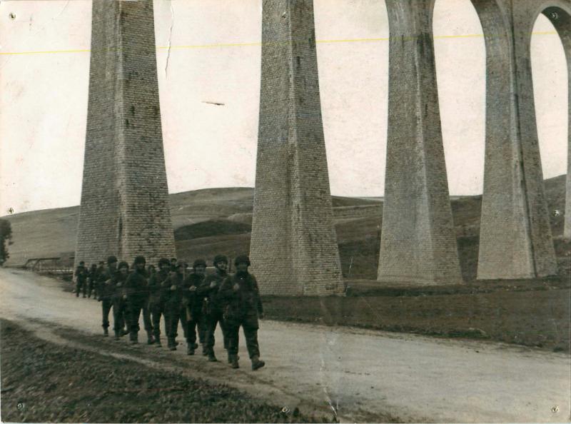 Men of 1st Parachute Squadron RE march under an aqueduct in the Tamera Valley.