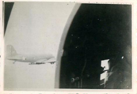 Photo taken from jumping door of Douglas Dakota aircraft. A second plane can be seen through theopen door.
