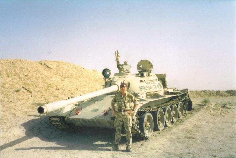Soldier from 4 PARA poses with an abandoned tank in the desert, Iraq, c.2004