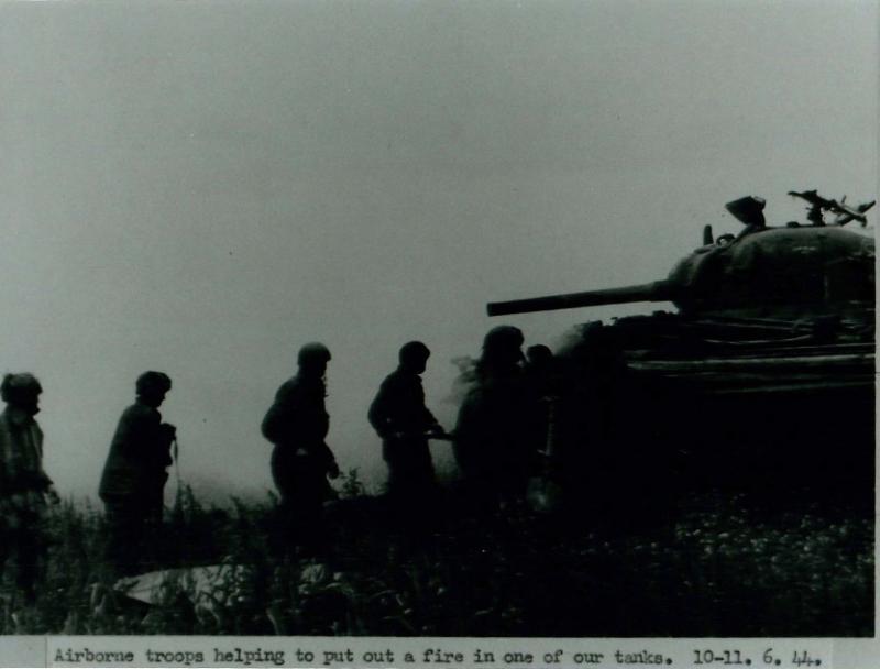 Airborne troops help put out a tank fire.