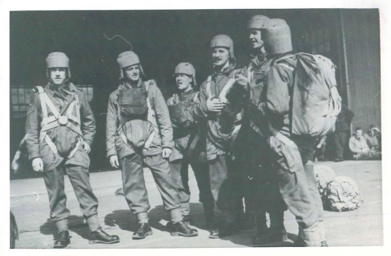 Line of paratroops showing the early parachute smock and experimental head protection.
